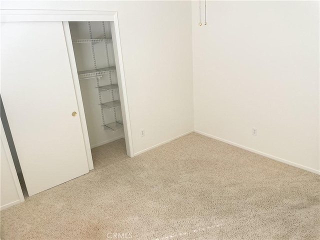 unfurnished bedroom with carpet floors, a closet, and baseboards