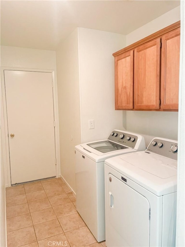 laundry area featuring cabinet space, light tile patterned floors, and washer and dryer