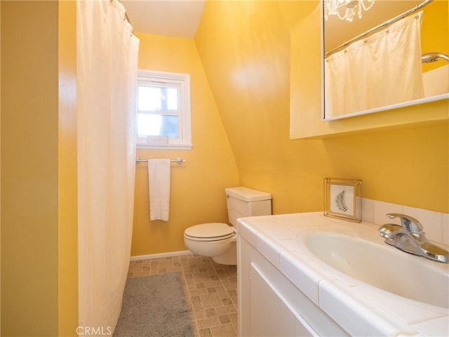 full bath with curtained shower, baseboards, toilet, vaulted ceiling, and vanity