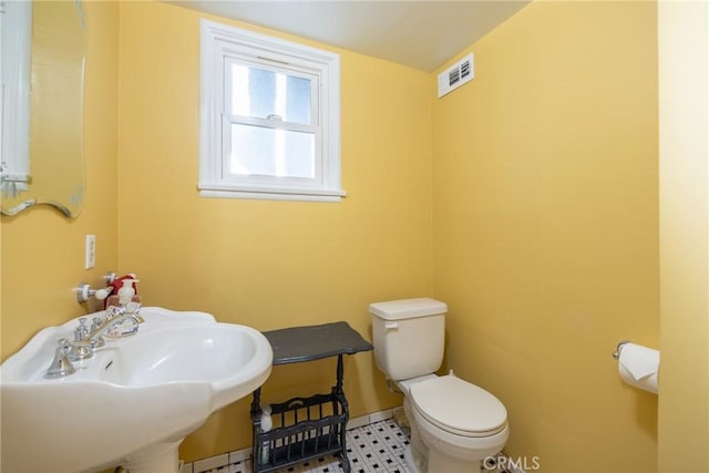 bathroom with a sink, visible vents, and toilet