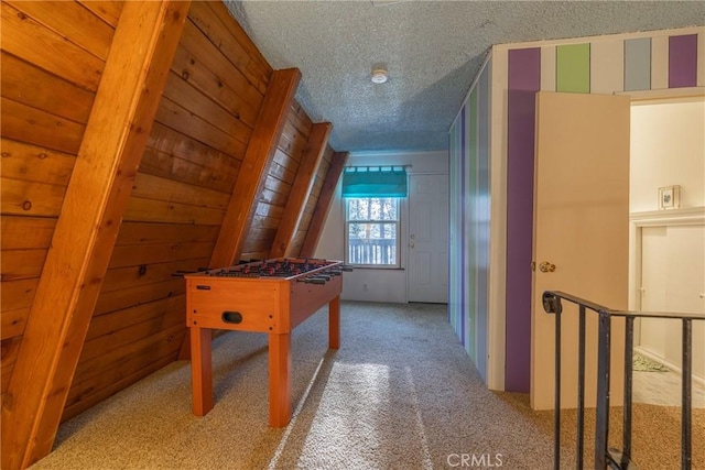 recreation room with a textured ceiling and carpet flooring