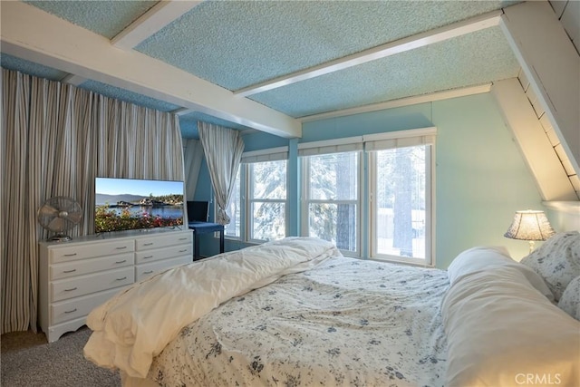 bedroom with beam ceiling, a textured ceiling, and carpet