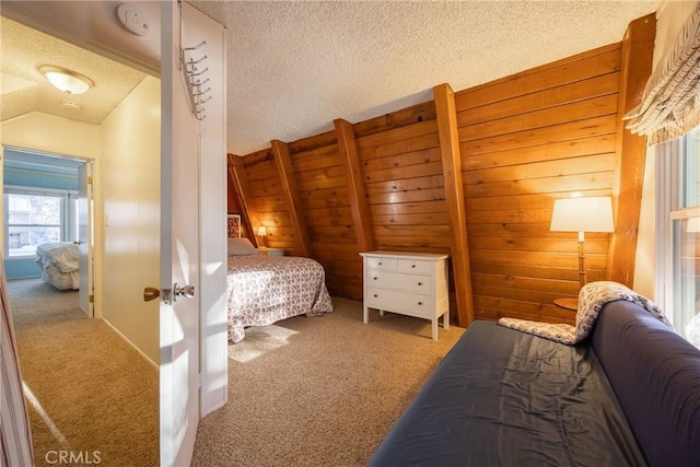 carpeted bedroom with lofted ceiling, wooden walls, and a textured ceiling