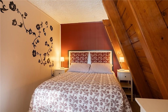 bedroom with wood walls and a textured ceiling