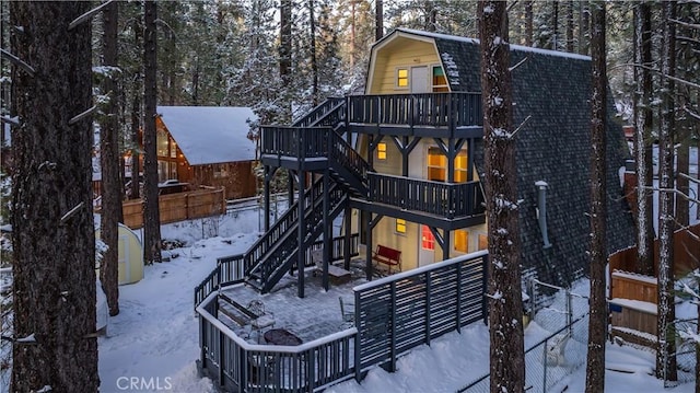 view of front of house with a gambrel roof, fence private yard, stairs, and a patio area