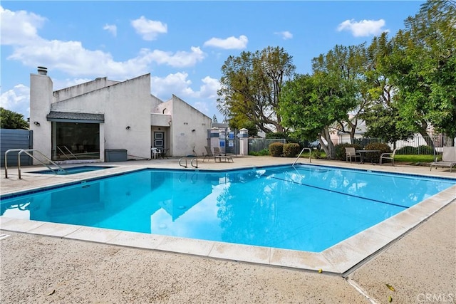 pool featuring a patio area, fence, and a community hot tub