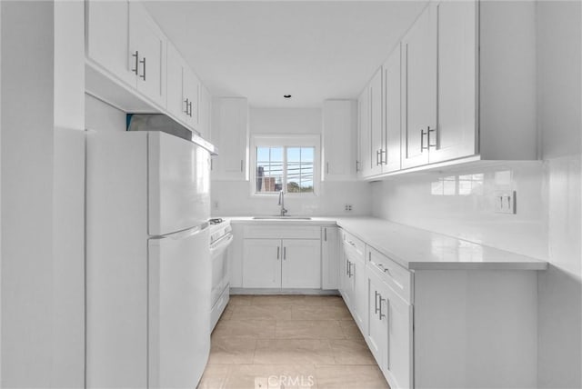 kitchen with white appliances, a sink, white cabinets, light countertops, and backsplash