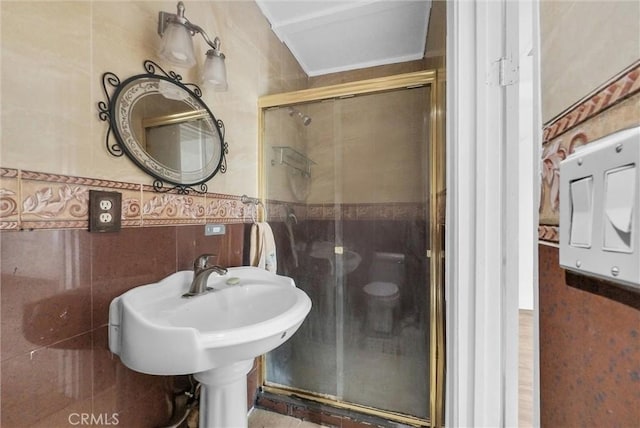 bathroom featuring tile walls and a shower stall