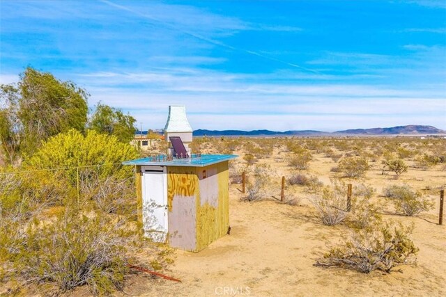 view of shed with view of desert and a mountain view