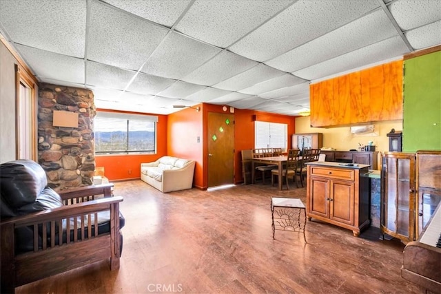 living area featuring a paneled ceiling and wood finished floors