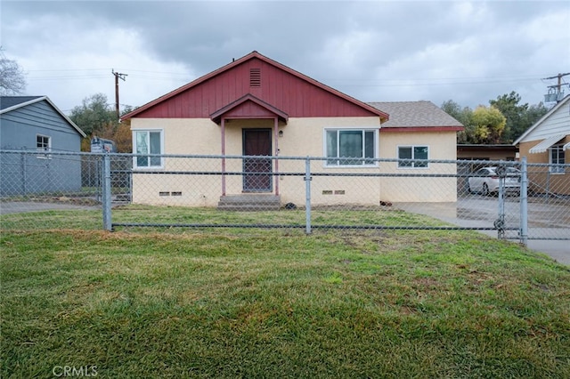 bungalow-style house featuring a fenced front yard, crawl space, and a front lawn