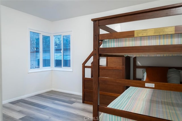 unfurnished bedroom with wood finished floors and baseboards