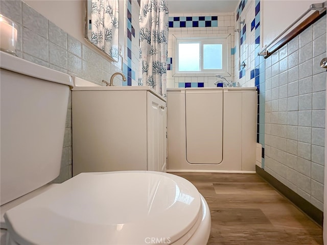 bathroom with tile walls and wood finished floors