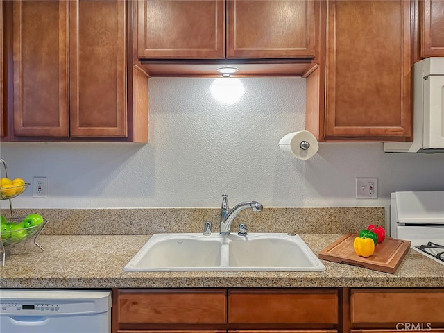 kitchen featuring light countertops, white dishwasher, and a sink