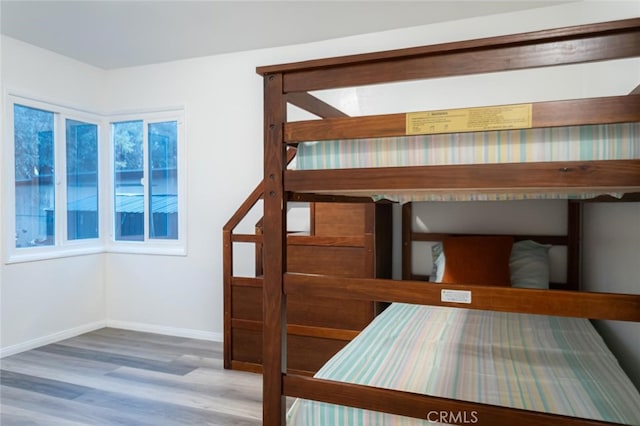 unfurnished bedroom featuring wood finished floors and baseboards