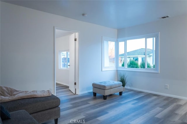 living area featuring visible vents, plenty of natural light, and wood finished floors