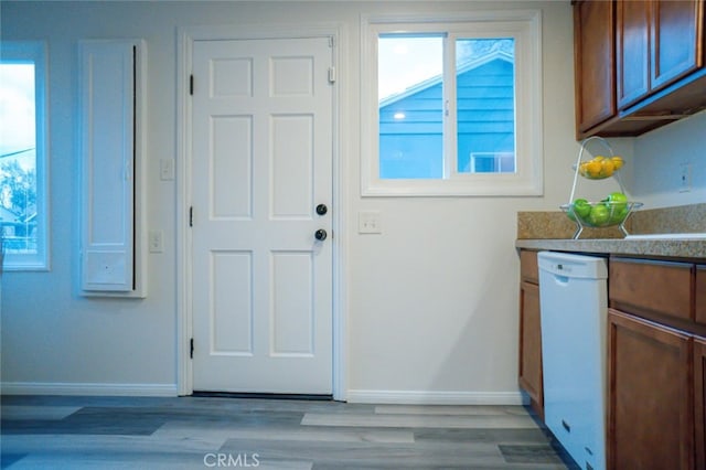 doorway with baseboards and light wood finished floors