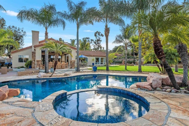 view of swimming pool with a yard, a patio area, and a pool with connected hot tub