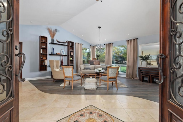 tiled foyer entrance with visible vents, baseboards, a notable chandelier, and vaulted ceiling