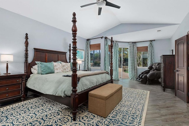 bedroom featuring multiple windows, wood finished floors, lofted ceiling, and access to outside