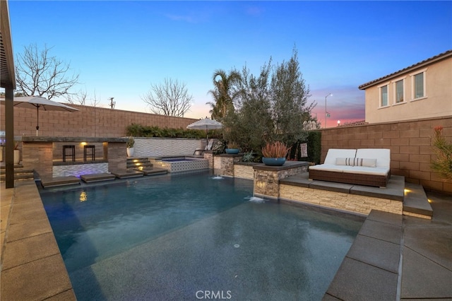 pool at dusk with a patio area, a fenced in pool, a fenced backyard, and an outdoor hangout area