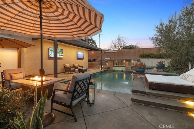 view of swimming pool with a patio, an outdoor living space with a fire pit, and fence