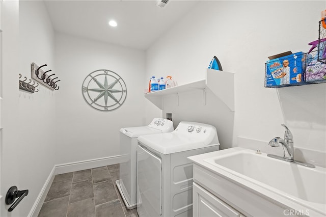 washroom featuring laundry area, washing machine and dryer, baseboards, and a sink