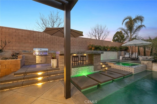 view of pool featuring grilling area, exterior kitchen, outdoor wet bar, a fenced backyard, and an in ground hot tub