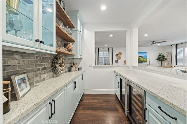 bar featuring dark wood-type flooring, tasteful backsplash, recessed lighting, wine cooler, and baseboards