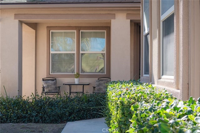 doorway to property featuring stucco siding