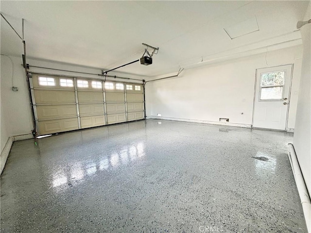 garage featuring a garage door opener and baseboards