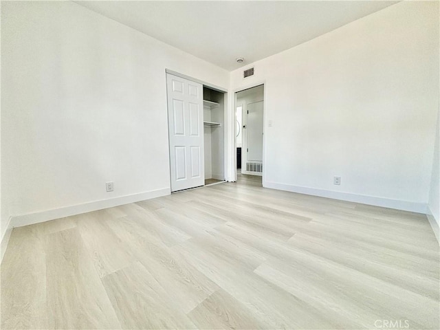 unfurnished bedroom featuring light wood-type flooring, visible vents, and baseboards