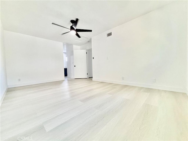 spare room with light wood-style flooring, visible vents, and baseboards