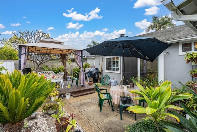 view of patio / terrace featuring fence, a deck, and a gazebo