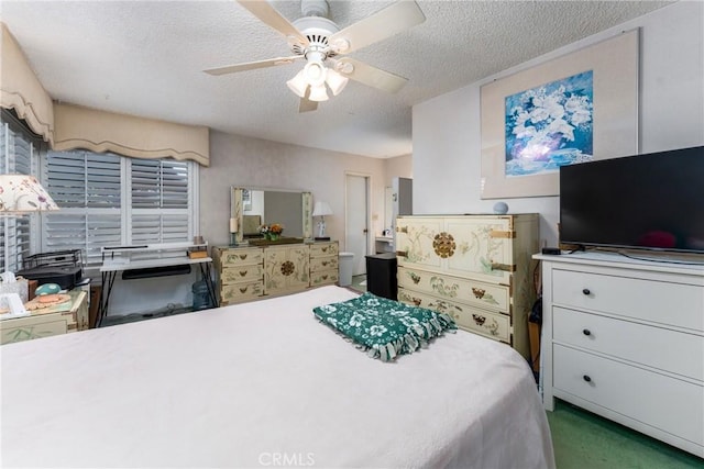 carpeted bedroom featuring a textured ceiling and a ceiling fan