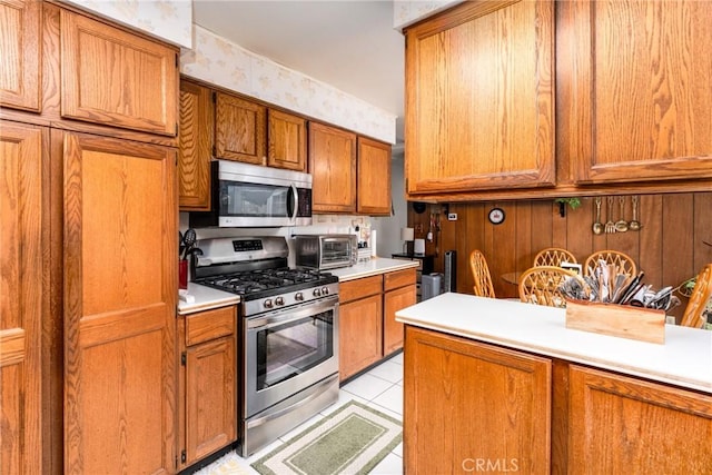 kitchen featuring light countertops, appliances with stainless steel finishes, and brown cabinets