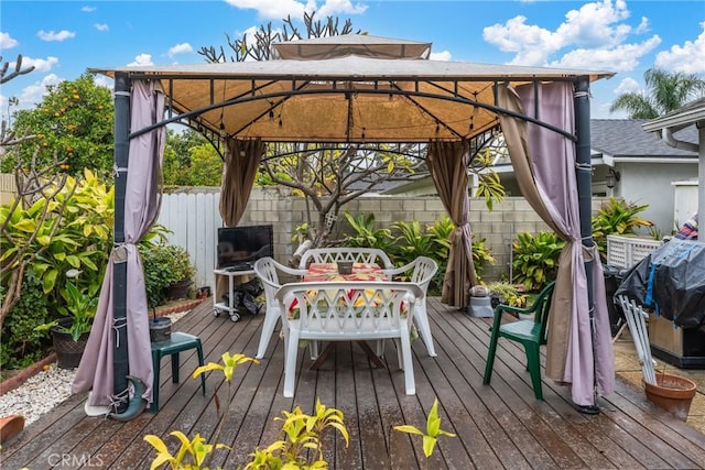 wooden terrace featuring fence and a gazebo