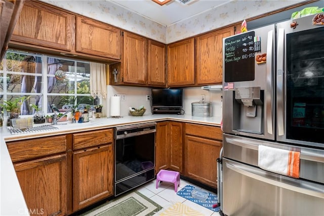 kitchen featuring black dishwasher, light countertops, wallpapered walls, and stainless steel fridge with ice dispenser