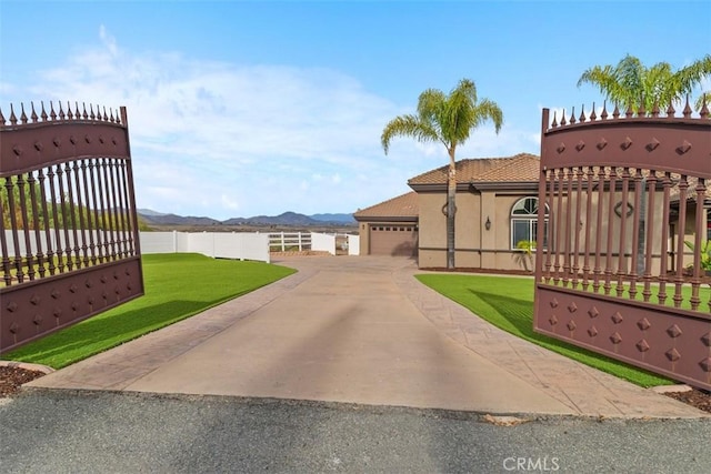 view of gate featuring a yard, fence, and a mountain view