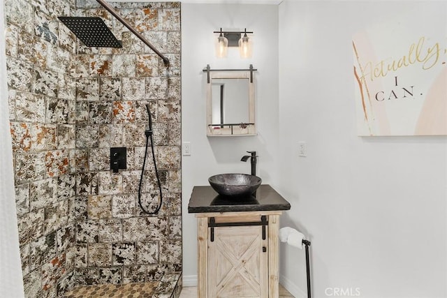 full bath with tiled shower and vanity