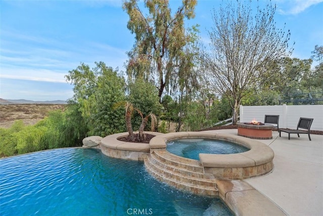 pool with an in ground hot tub, an outdoor fire pit, and a patio