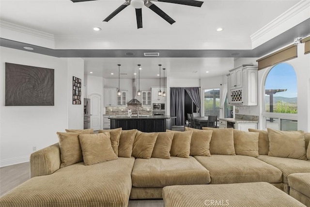 living room with recessed lighting, visible vents, light wood-style floors, and crown molding