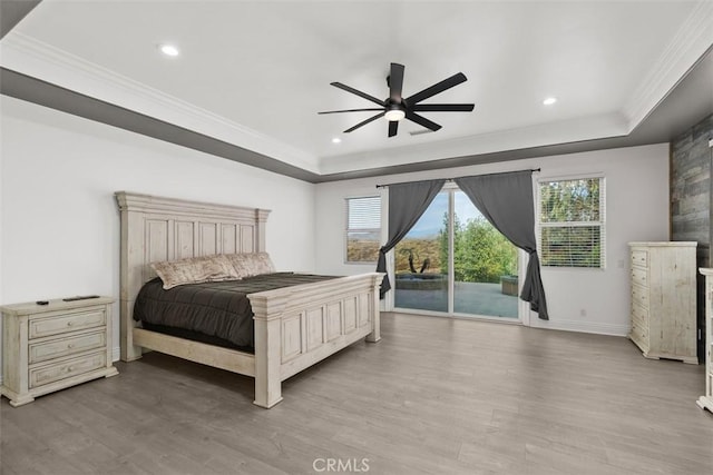 bedroom with access to exterior, multiple windows, wood finished floors, and ornamental molding