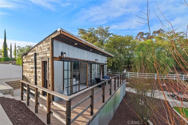 back of property with fence and stone siding