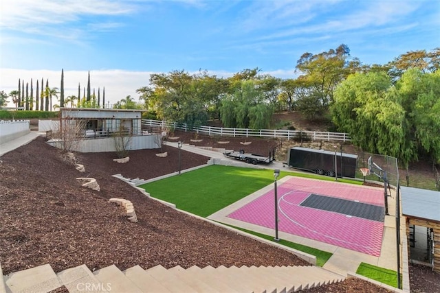 view of basketball court with community basketball court, a yard, and fence