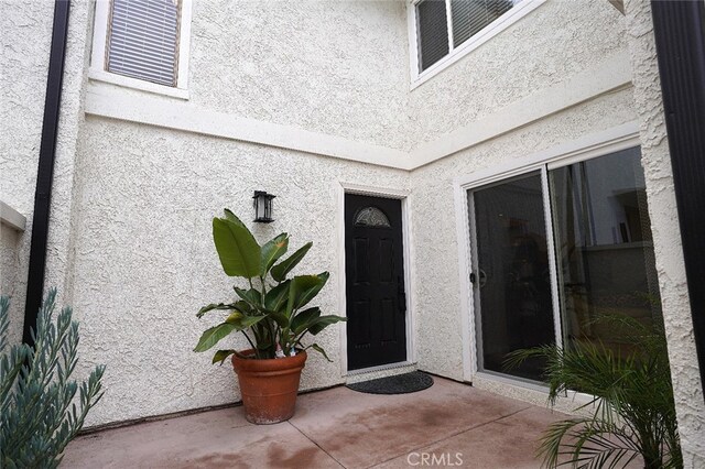 entrance to property featuring stucco siding and a patio area