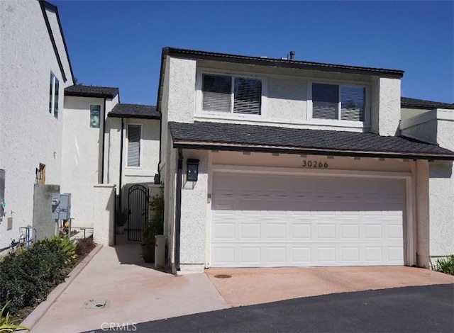 view of front of home with concrete driveway, a garage, and stucco siding