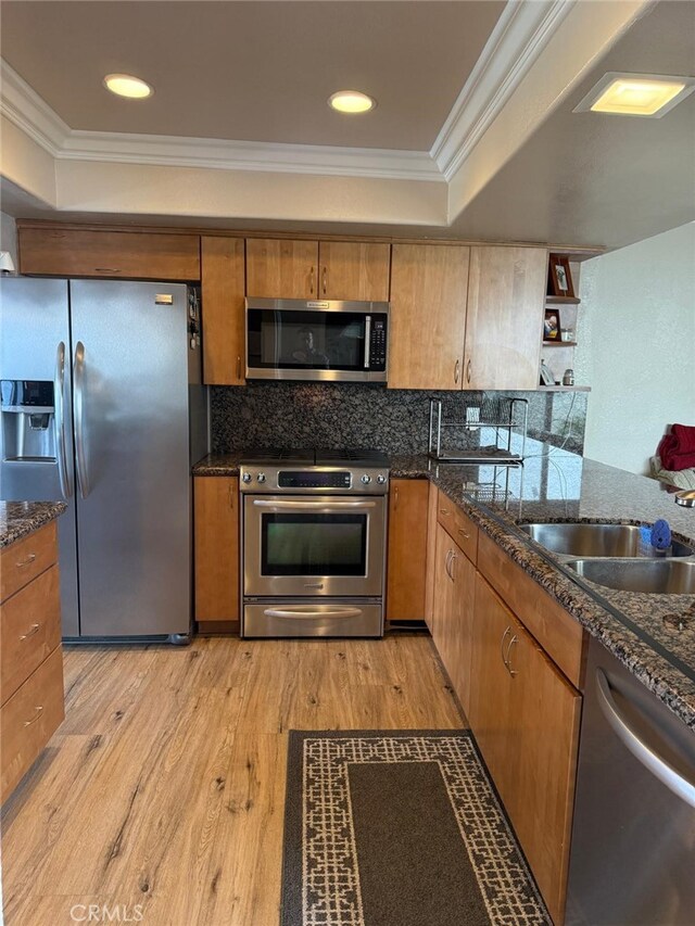 30266 Via Reata, Laguna Niguel, CA 92677 - kitchen with appliances with stainless steel finishes, a tray ceiling, light wood-style floors, crown molding, and tasteful backsplash