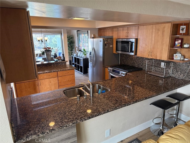 30266 Via Reata, Laguna Niguel, CA 92677 - kitchen with stainless steel appliances, a sink, a peninsula, and dark stone counters