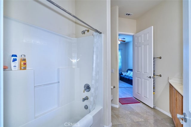 bathroom featuring baseboards, visible vents, toilet, shower / bath combination with curtain, and vanity